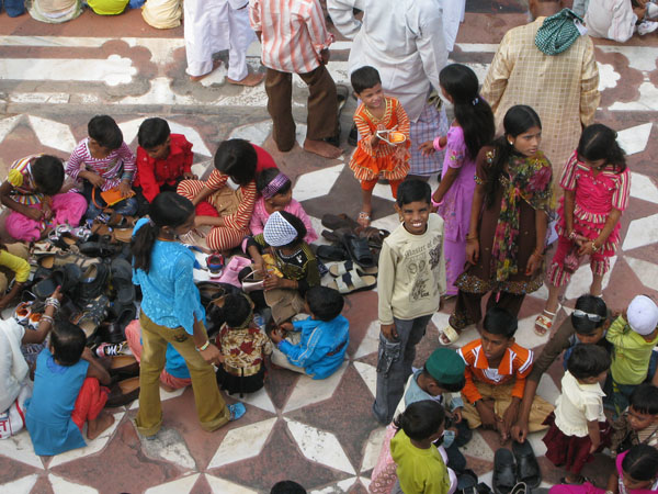 While their fathers and brothers prayed, the children circled around the shoes at the back.