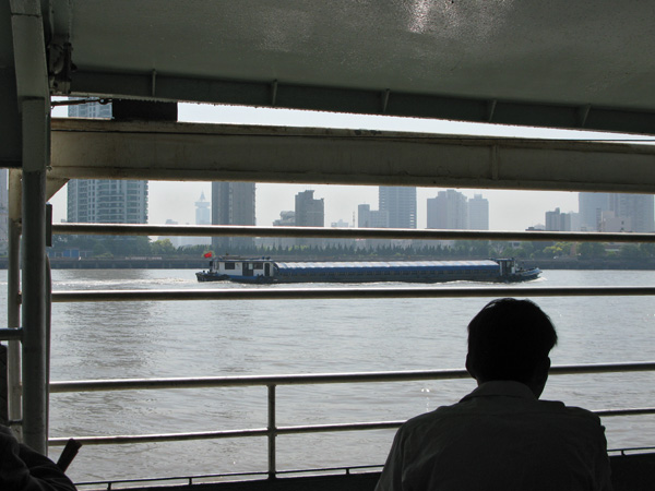 Our ferry waits as barges cross our path